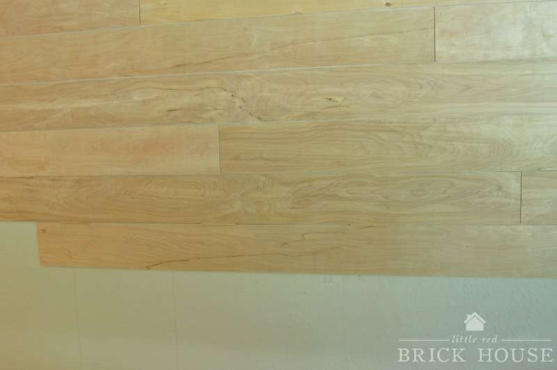 unpainted shiplap planks nailed to the wall in a staggered pattern