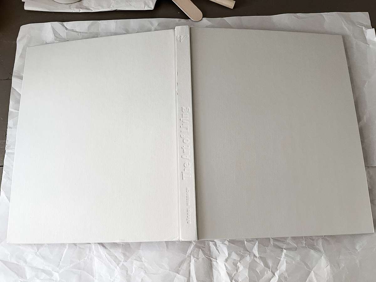 third coat of a book cover being painted light gray