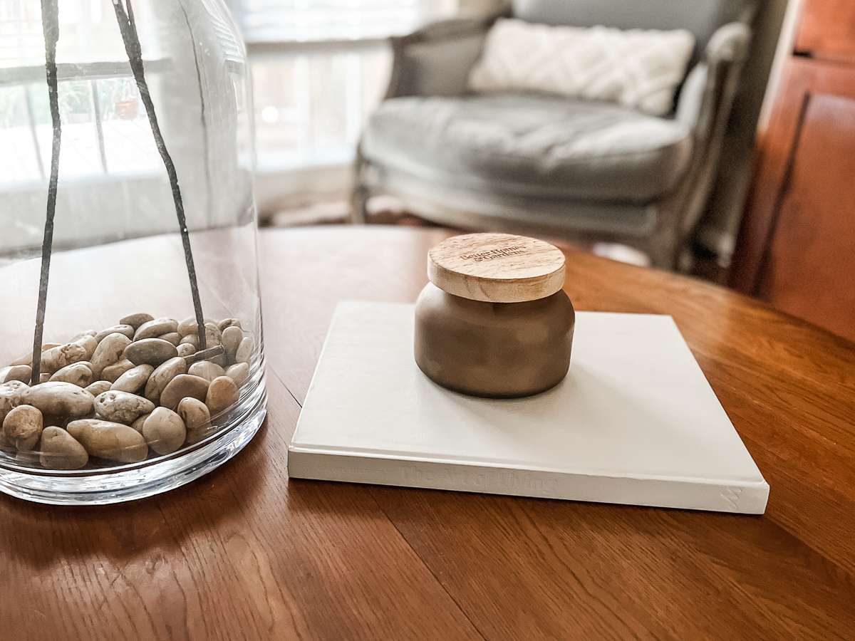 light gray book on a coffee table with a candle on top